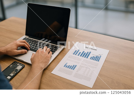 Businessman studying tariff cost charts during international economic tension between global trade partners, analyzing the impact on supply and pricing 125043056