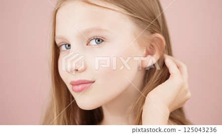 Close up headshot beautiful Caucasian girl posing look at camera isolated on pink background, charming smile, natural beauty Gen Alpha portrait. Adverts for skincare cosmetics for teengers or children 125043236