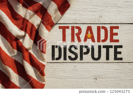 TRADE DISPUTE painted on wood with fabric resembling USA flag, symbolizing commercial conflict, tensions and international economic confrontation 125043273