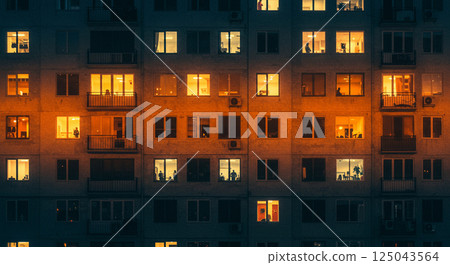 A glimpse of night life through the windows of lit-up buildings 125043564
