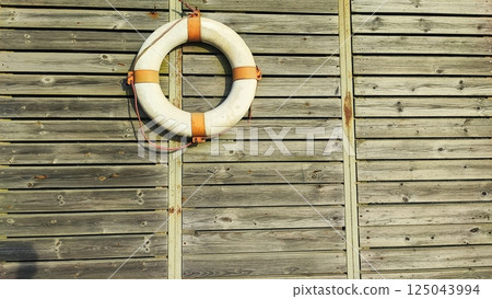 Life preserver on a wooden boardwalk. rustic style decor Life preserver on a wooden boardwalk. rustic style decor 125043994