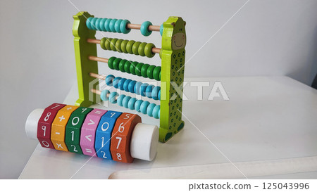 Children's wooden construction set, abacus, on a white table. Concept of children's development, montesori Children's wooden construction set, abacus, on a white table. Concept of children's development, montesori 125043996