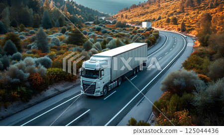 white European semitruck is seen from the sky on a highway backed by vegetation 125044436