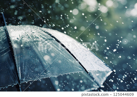Close up, transparent umbrella under rainfall against a background of water droplets splashing. Concept of rainy weather. 125044609