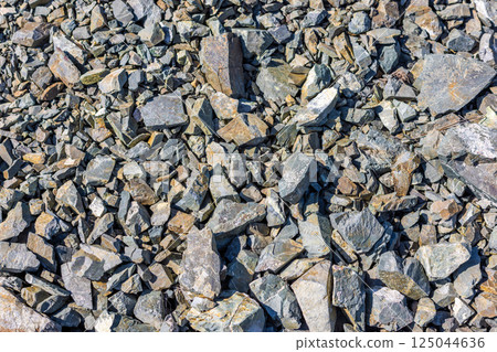 Pile of various gray and brown natural rocks and stones under bright sunlight - full-frame 125044636