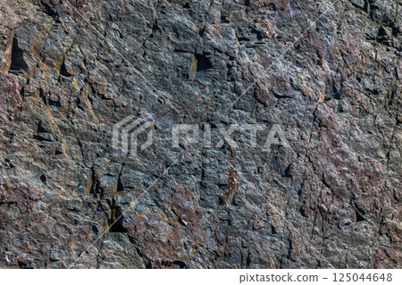 Roughly cleaved metamorphic rock, splintery texture, natural surface, outdoor, daylight 125044648