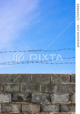 Barbed Wire Above Concrete Block Wall Barbed Wire Above Concrete Block Wall 125044669