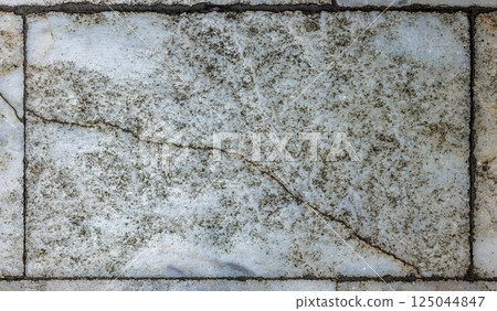 Worn Grey and White Mottled Marble Floor Tile With Crack 125044847