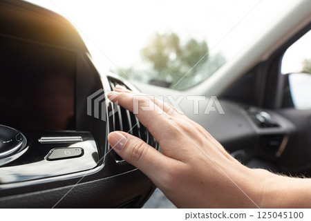 Woman check air condition in car 125045100