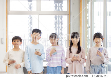 Elementary school students with smartphones 125046940