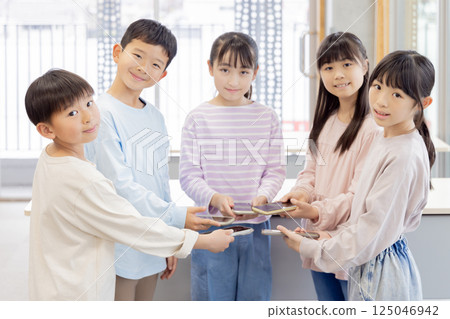 Elementary school students with smartphones Elementary school students with smartphones 125046942
