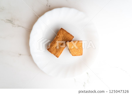 Two slices of baked goods on a white plate ① 125047326
