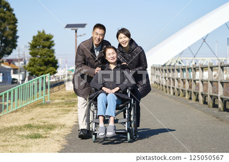 Portrait of a mother and her child, with the mother in a wheelchair 125050567
