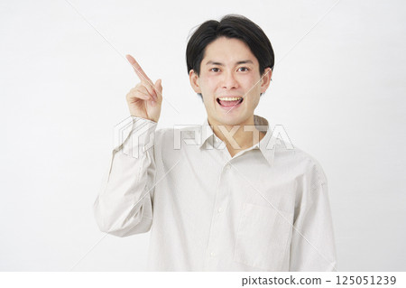 一名 20 多歲的男子指向左側，白色背景 125051239
