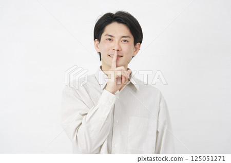 Man in his 20s, secret gesture, white background Man in his 20s, secret gesture, white background 125051271