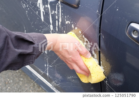 The hands of a man in his 40s washing a car at home The hands of a man in his 40s washing a car at home 125051790