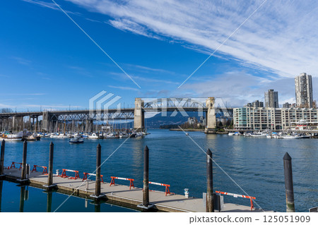 BC, Canada. Granville Island Ferry Dock. Burrard Street Bridge and Vancouver buildings skyline in the background. 125051909