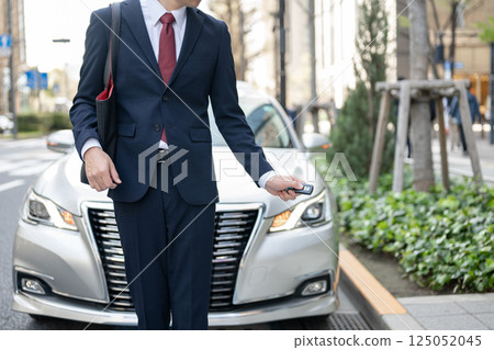 站立在汽車前面的商人 站立在汽車前面的商人 125052045