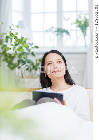Woman operating a tablet indoors | Reading and studying | Healthy living image | Well-being girl | Well-being Woman operating a tablet indoors | Reading and studying | Healthy living image | Well-being girl | Well-being 125052303