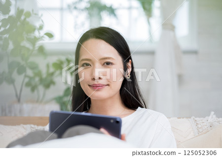 Woman using tablet in bed | Reading and studying | Healthy living image | Well-being girl | Well-being 125052306
