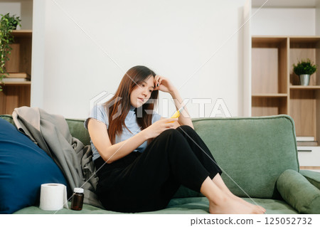 Asian Woman sitting in the sofa with a large number of pills Depressed woman wants to kill herself by drug overdose, depression concept. 125052732