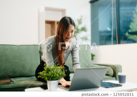 Young asian woman relax on comfortable couch at home texting messaging on smartphone and tablet Young asian woman relax on comfortable couch at home texting messaging on smartphone and tablet 125052831