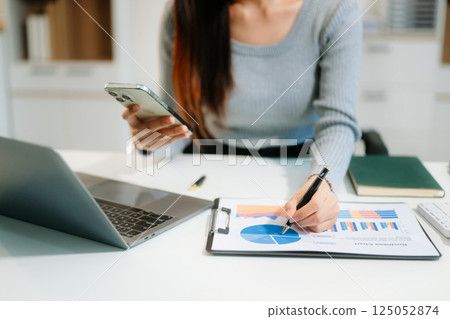 Confident businessman working on laptop, tablet and smartphone at her workplace 125052874