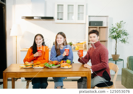Young Asian friend having, enjoy evening party together at home. Attractive young man and woman having fun Young Asian friend having, enjoy evening party together at home. Attractive young man and woman having fun 125053076