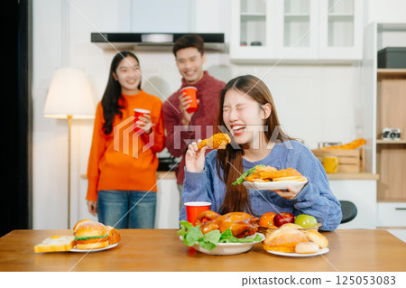 Young Asian friend having, enjoy evening party together at home. Attractive young man and woman having fun Young Asian friend having, enjoy evening party together at home. Attractive young man and woman having fun 125053083