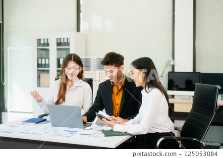 Office colleagues have a casual discussion. During a meeting in a conference room, a group of business teem 125053084