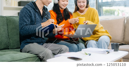 Group of young adults in casual wear, using laptops and headphones, enjoying teamwork, creativity, and learning Group of young adults in casual wear, using laptops and headphones, enjoying teamwork, creativity, and learning 125053110