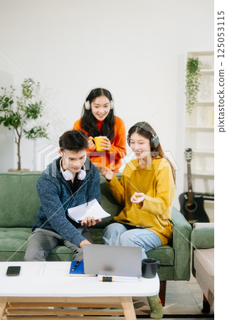 vibrant teamwork, creativity, and learning with young adults using laptops and headphones  in cozy 125053115