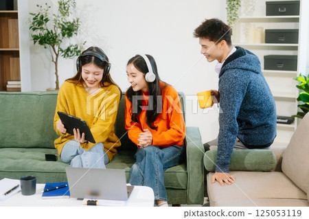 vibrant teamwork, creativity, and learning with young adults using laptops and headphones  in cozy 125053119