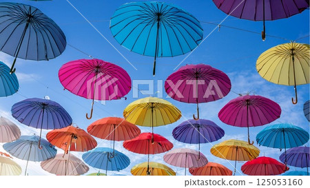 Colorful umbrellas in the blue sky Colorful umbrellas in the blue sky 125053160