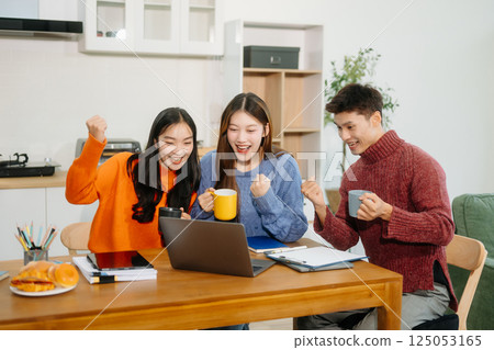 Teamwork and creativity with young adults collaborating on laptops and tablets in a cozy workspace. Teamwork and creativity with young adults collaborating on laptops and tablets in a cozy workspace. 125053165