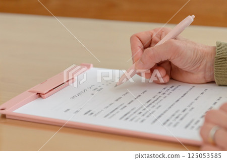 女人的手在諮詢單上寫字 女人的手在諮詢單上寫字 125053585