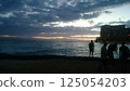Hawaii: Surfers looking out at the ocean from a cloudy beach 125054203