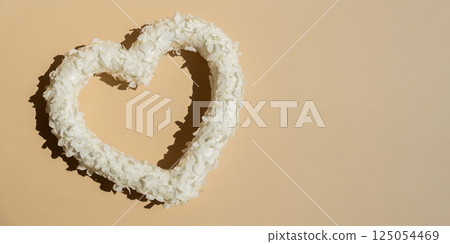 White lilac flowers heart shaped in pastel backdrop. Symbol of love floral arrangement. Spring concept idea Valentine's Day, weeding proposal postcard copy space White lilac flowers heart shaped in pastel backdrop. Symbol of love floral arrangement. Spring concept idea Valentine's Day, weeding proposal postcard copy space 125054469