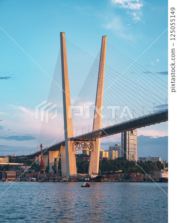 View of the Zolotoy Bridge in Vladivostok with Ships in the Harbor at Sunset View of the Zolotoy Bridge in Vladivostok with Ships in the Harbor at Sunset 125055149