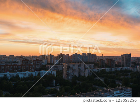 Sunset over urban landscape with vibrant colors illuminating buildings in city skyline Sunset over urban landscape with vibrant colors illuminating buildings in city skyline 125055256