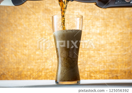 Draft beer being poured into a glass 125056392