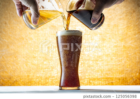 Draft beer being poured into a glass 125056398