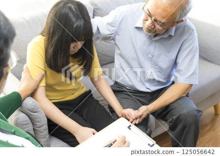 Parents telling the psychologist about family or child problems. Depressed girl and her parent or grandpa having session with psychiatrist in clinic. Parents telling the psychologist about family or child problems. Depressed girl and her parent or grandpa having session with psychiatrist in clinic. 125056642