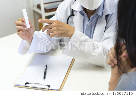 Male doctor show Rapid Antigen Test kit with Negative result to female patient. Male doctor show Rapid Antigen Test kit with Negative result to female patient. 125057110