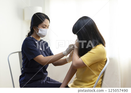 Asian Girl Getting Vaccinated, Receiving Coronavirus Vaccine Injection in clinic. 125057490