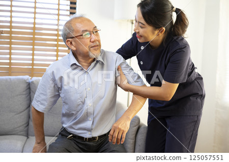 Medical assistance. Asian female nurse help Senior asian man getting up from the sofa while staying at the nursing home. Medical assistance. Asian female nurse help Senior asian man getting up from the sofa while staying at the nursing home. 125057551