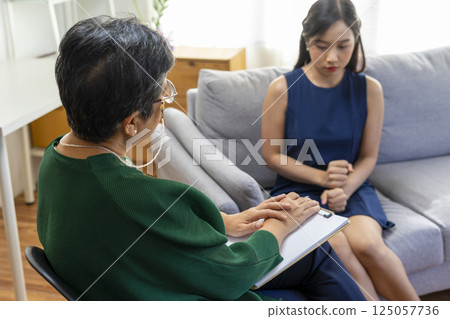 Asian psychologist doctor having session with young depressed woman in clinic. Psychology and mental therapy concept. Asian psychologist doctor having session with young depressed woman in clinic. Psychology and mental therapy concept. 125057736