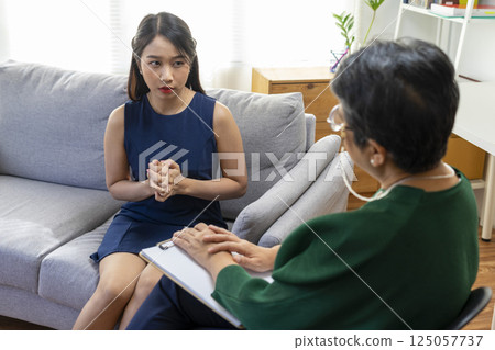 Asian psychologist doctor having session with young depressed woman in clinic. Psychology and mental therapy concept. Asian psychologist doctor having session with young depressed woman in clinic. Psychology and mental therapy concept. 125057737