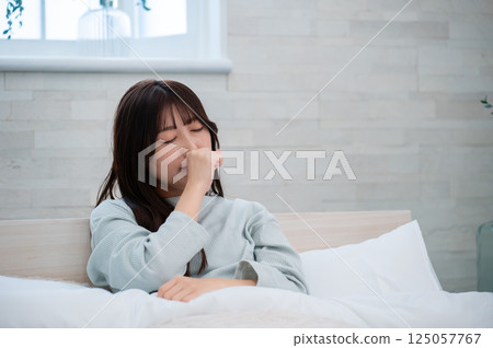 一個女人在床上打哈欠 一個女人在床上打哈欠 125057767