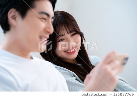男人和女人笑著看智能手機 125057769